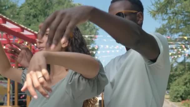 今年夏季 一对非洲裔美国男人和一个高加索裔女人手牵着手跳着婚纱舞 他们在一个喜庆的街道上欢欢喜喜地跳着 — 图库视频影像