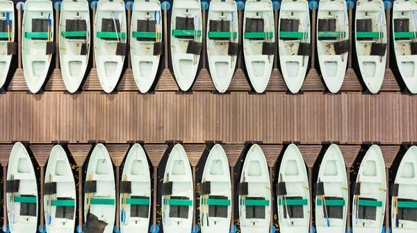 市立公園の湖の列でも木製の桟橋に立っている喜びのボート 上下の景色 ストック写真