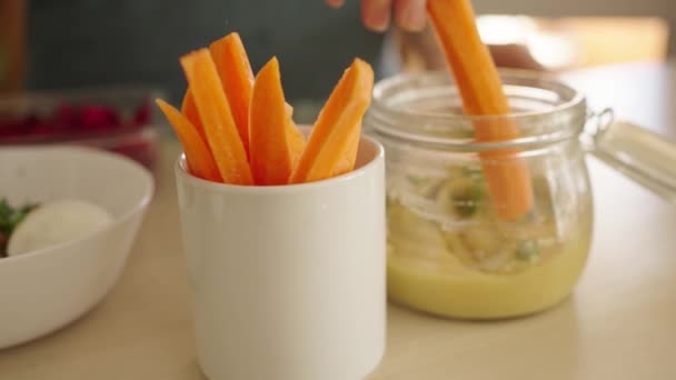 Womans Hand Takes Homemade Hummus Puree Glass Jar Chopped Carrots — Stok Video
