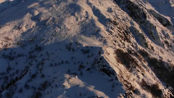落日时陡峭的悬崖峭壁和灌木覆盖着雪山的全景 空中尽收眼底 一个美丽的山景的电影拍摄 一个没有人的大规模的自然景观 — 图库视频影像