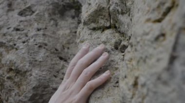 Kaya tırmanışçılarının kaba kuvvete sıkıca sarıldığını gösteren detaylı bir görüntü. Bir kaya tırmanıcısı yüksek bir dağa tırmanır, etkin bir açık hava sporudur..