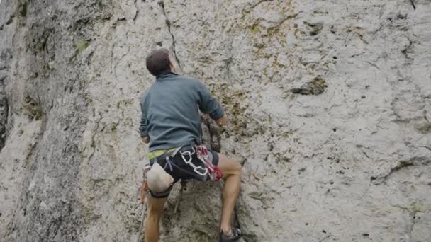 Альпинист Растягивается Сделать Следующий Шаг Крутой Скале Оборудованный Мешком Ремнем — стоковое видео