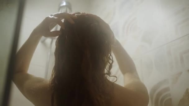 Vista Trasera Una Mujer Desnuda Ducha Enjabonando Cabello Bajo Agua — Vídeos de Stock