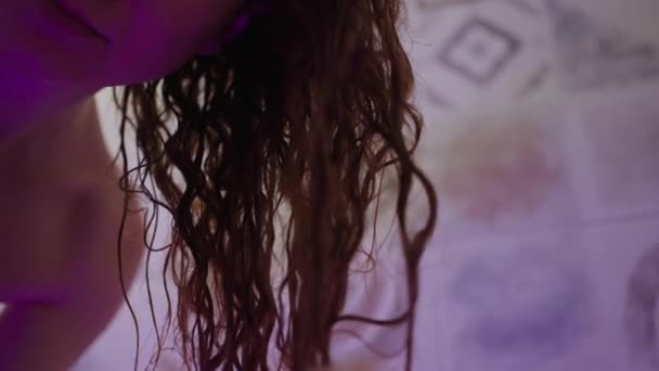 浴室里的一个女人在霓虹灯下洗头后 在她的卷发上涂了护发素 身体护理 美容疗法 — 图库视频影像