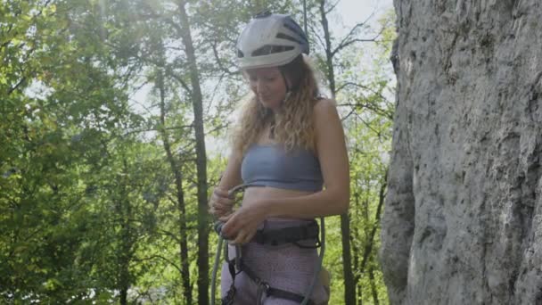 Женщина Альпинистка Привязывает Веревку Ремню Безопасности Стоя Скале Перед Восхождением — стоковое видео