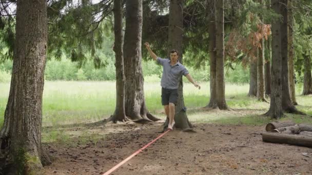 Skoncentrowany Człowiek Balansujący Między Drzewami Lesie Mężczyzna Ostrożnie Spaceruje Rozciągniętym — Wideo stockowe
