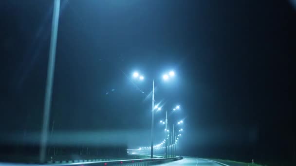 第一眼看到的是一条有灯的汽车路 晚上用工作的雨刷在雾中 乘车旅行 — 图库视频影像