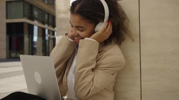 Energisk Framgångsrik Afroamerikansk Affärskvinna Lyssnar Musik Hörlurar Medan Sitter Mot — Stockvideo