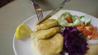 Vejetaryen falafel köfteleri sebzeli ve kırmızı lahana bir bıçak ve çatalla kesilir. Sağlıklı bir sebze kahvaltısı. Izgara Halloumi, Taze Salata ve Kırmızı Lahana ile Vejetaryen Yemekleri 