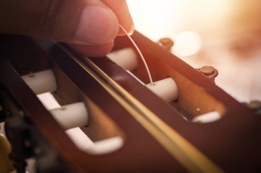 Restring classical guitar concept. Closeup at the new strings.