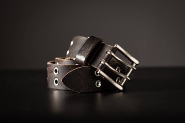 Rock style leather belt for men. Isolate genuine leather belt over black background. 