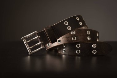 Rock style leather belt for men. Isolate genuine leather belt over black background. 