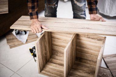 The man assembling new furniture at his home.