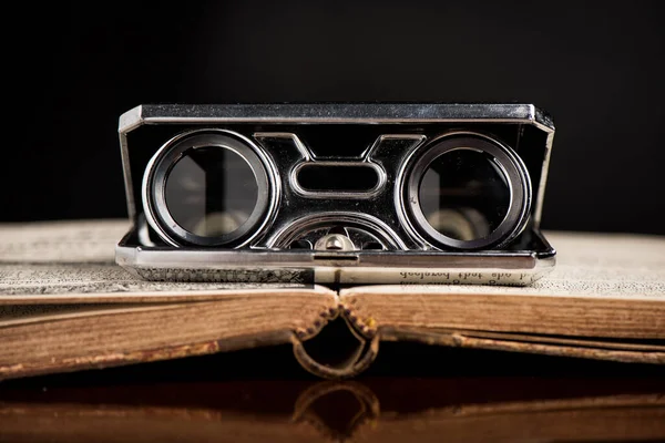 Closeup vintage folding opera glasses. Old compact binoculars.