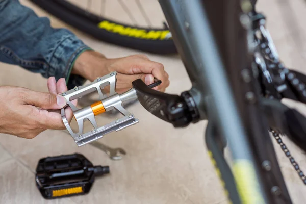 The man changing bike pedals. Mountain bike upgrade concept.