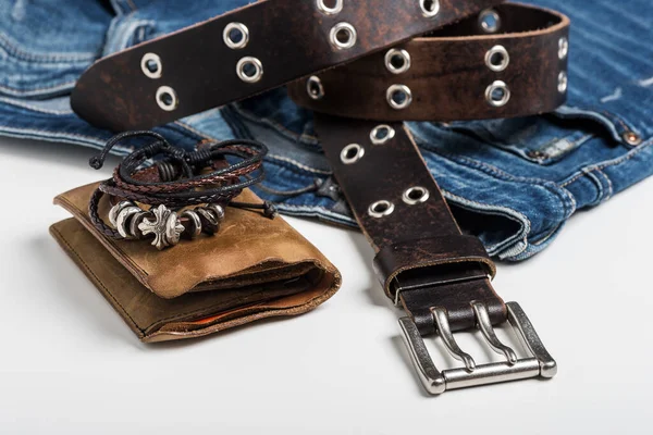 Blue jeans and men accessories. Closeup brown genuine leather belt with rock style.