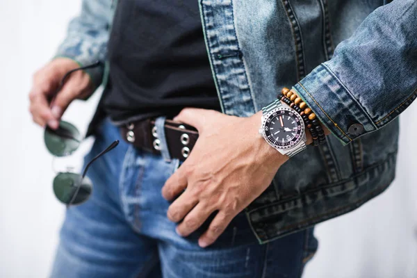 closeup luxury men watch with black dial and stainless steel bracelet on wrist of man.
