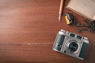 Old film camera on wooden desktop.