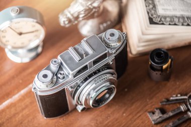 Old film camera on wooden desktop.