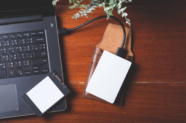 Closeup external hard drive on wooden desktop. Working with external hard drive.