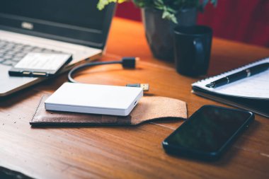 Closeup external hard drive on wooden desktop. Working with external hard drive.