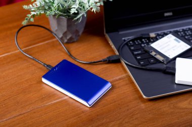 Closeup external hard drive on wooden desktop. Working with external hard drive.
