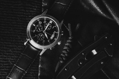 Closeup at luxury men wristwatch with black dial and leather strap.