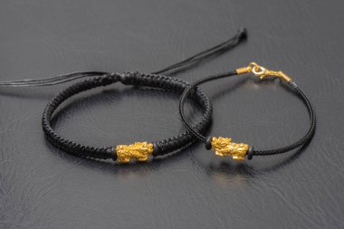 Wealth PiXiu bracelet, closeup at the gold PiXiu. PiXiu is a Chinese mythical auspicious creature, also known as PiYao. 