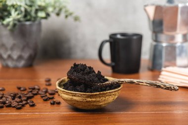closeup used coffee grounds in wooden spoon