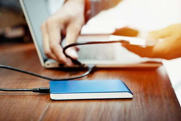 stock image Closeup external hard drive on wooden desktop. Working with external hard drive.