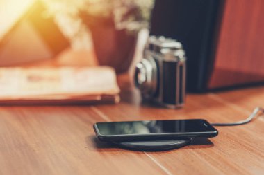 Akıllı telefonu masaüstünde kablosuz şarj cihazıyla şarj etmek.
