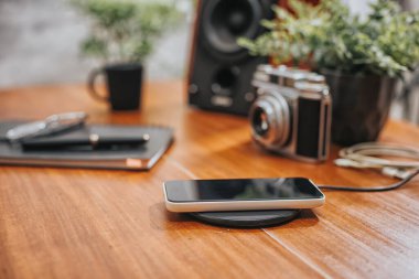Akıllı telefonu masaüstünde kablosuz şarj cihazıyla şarj etmek.