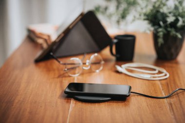 Akıllı telefonu masaüstünde kablosuz şarj cihazıyla şarj etmek.