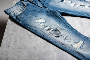 Kot pantolonun yırtılmasının yakın çekimi. Moda mavisi kot pantolon.