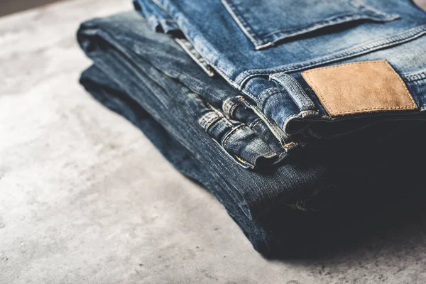 Veel Blauwe Jeans Een Betonnen Ondergrond Herenmode Denim Jeans — Stockfoto