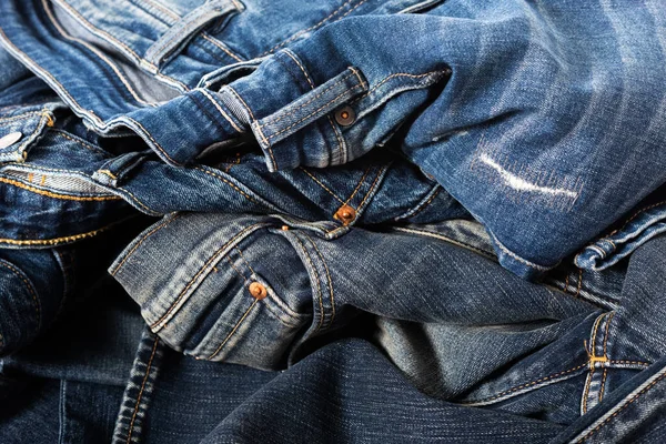 heap of fashion denim jeans over white background.