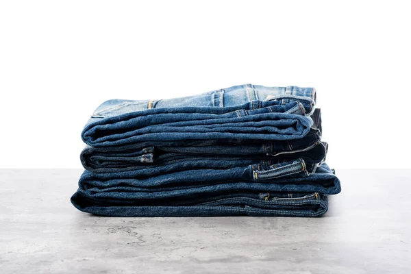 many blue jeans. men fashion denim jeans stacked over white background.