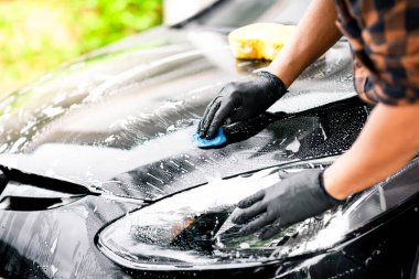 Siyah arabayı yıkıyorum. Araba temizliği ve araba bakımı konsepti.