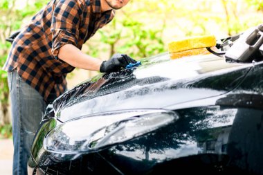 Siyah arabayı yıkıyorum. Araba temizliği ve araba bakımı konsepti.