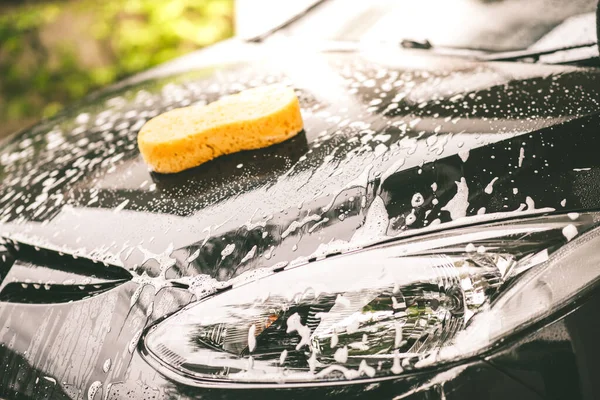 洗黑色的车 汽车清洗和汽车维修概念 免版税图库图片