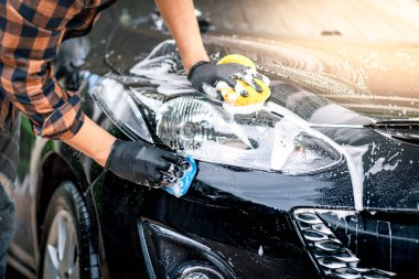 Siyah arabayı yıkıyorum. Araba temizliği ve araba bakımı konsepti.