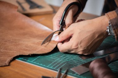 Atölyede hakiki deriyle çalışan adam..