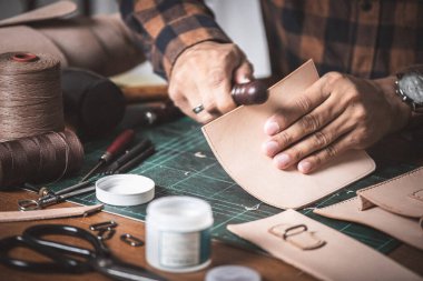 Atölyede hakiki deriyle çalışan adam..