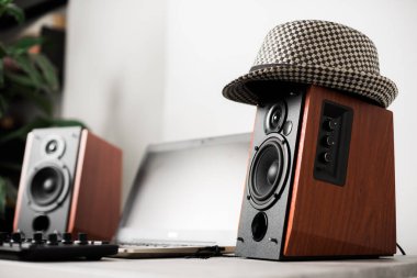 Stüdyoda hoparlörlü ve bilgisayarlı bir çalışma istasyonu. Ofisteki masaüstü. Hoparlöre odaklan.