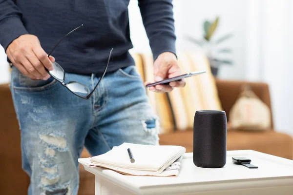 The man streams music from smartphone to bluetooth speaker.