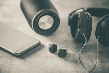 Akıllı telefonlu bir çift siyah, gerçek kablosuz kulaklık. Rahatlama kavramı.