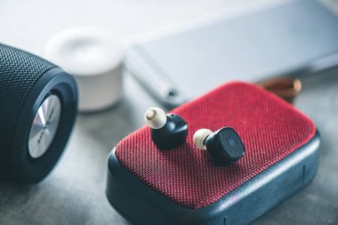 Akıllı telefonlu bir çift siyah, gerçek kablosuz kulaklık. Rahatlama kavramı.