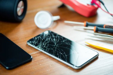 Teknisyen bozuk akıllı telefonu kırık ekranla tamir ediyor..