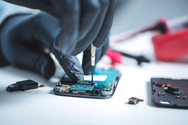 Teknisyen bozuk akıllı telefonu tamir ediyor. akıllı telefon servisi.