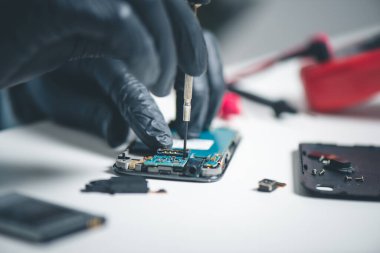 Teknisyen bozuk akıllı telefonu tamir ediyor. akıllı telefon servisi.